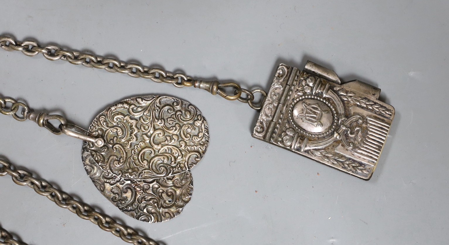 A 19th century plated five chain chatelaine, with a thimble holder, a silver Vesta and a medallion, a note book and two oval metal panels